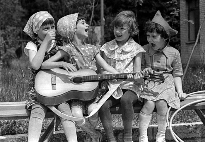 Дівчата, які відіграють на гітарі в шкільному дворі. 