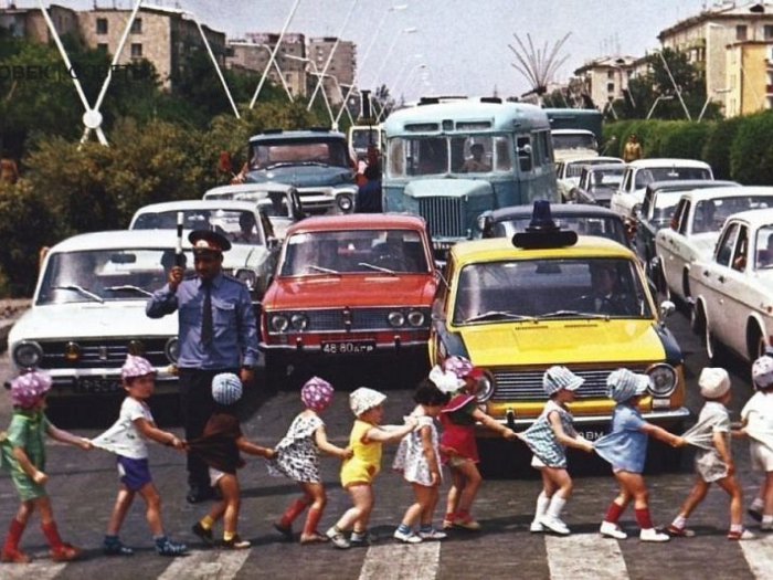 Міліціонер зупинив рух для безпечного переходу дітей через дорогу. 